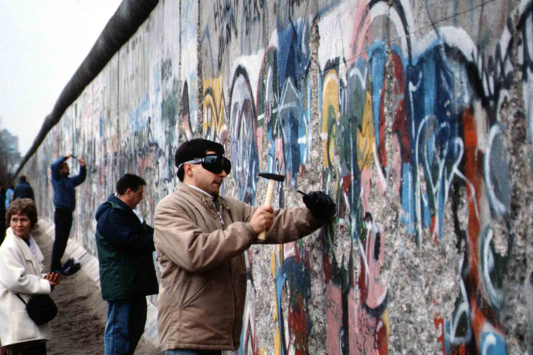 Berliners chip away at the Berlin Wall with hammers and chisels, November 1989 (Photo credit: Wikimedia Commons / Raphaël Thiémard