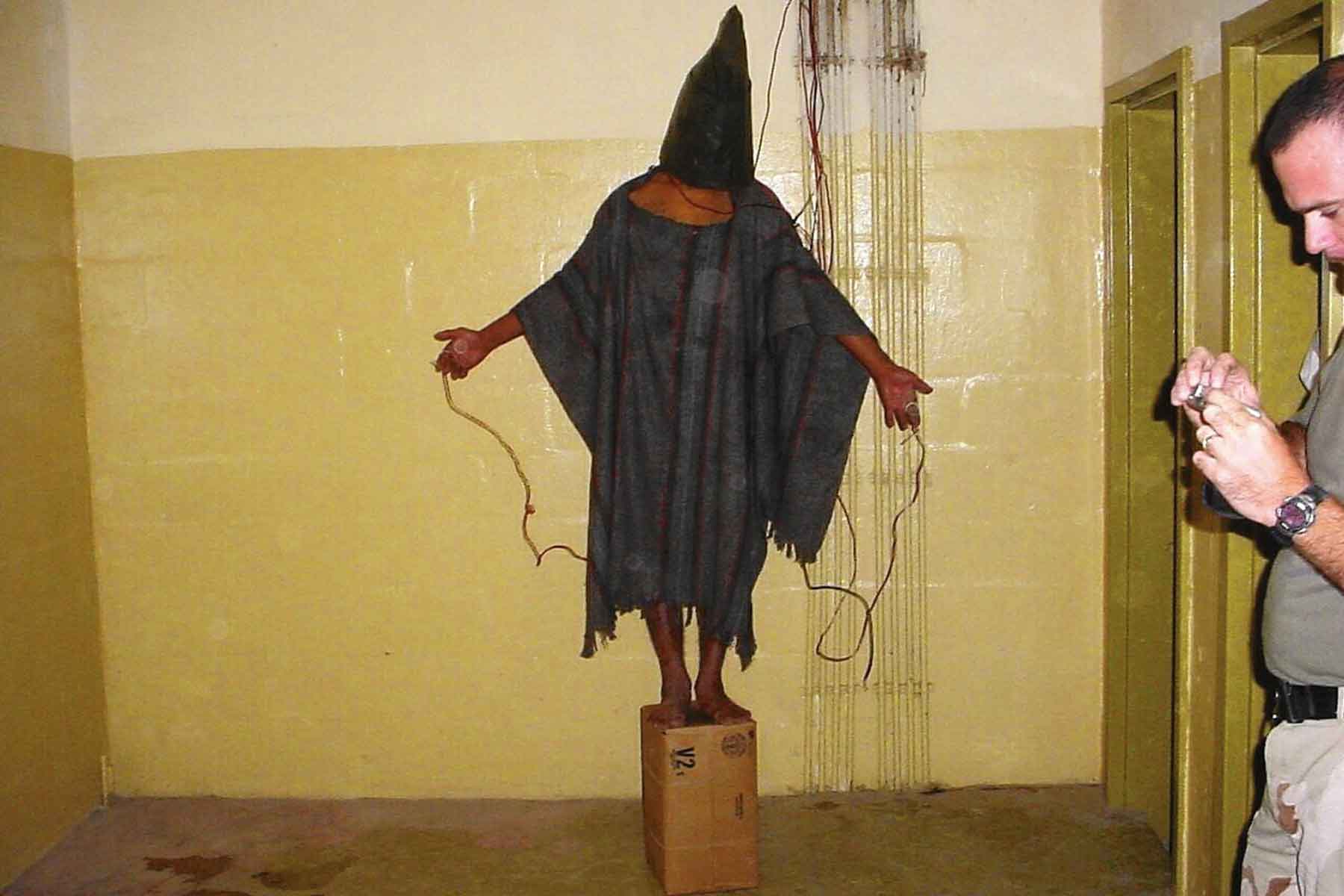 The infamous photo of an Iraqi detainee standing on a box, his head hooded and his fingers extended out and connected to wires.