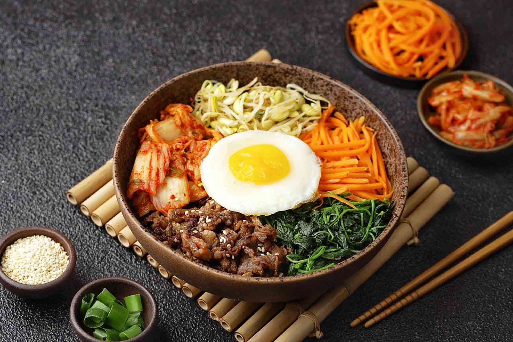 A Korean bibimbap bowl with mixed vegetables and seasoned beef on rice