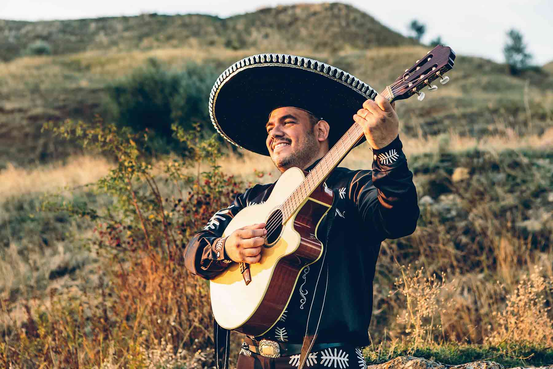 A mariachi musician playing the guitar outdoors A mariachi musician playing the guitar outdoors